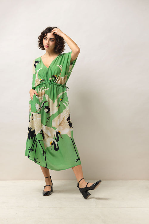 One Hundred Stars Stork Pea Green String Dress. A midi-length summer dress with a Grecian shape, V-neck, and a bright green & stork design