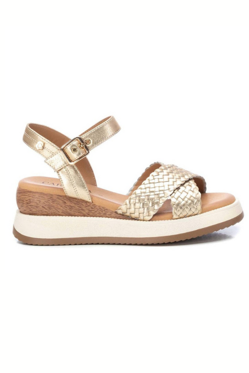 Carmela Sandal. A pair of gold platform sandals made from leather, featuring a shiny woven design. These sandals have a buckle closure and non-slip sole.