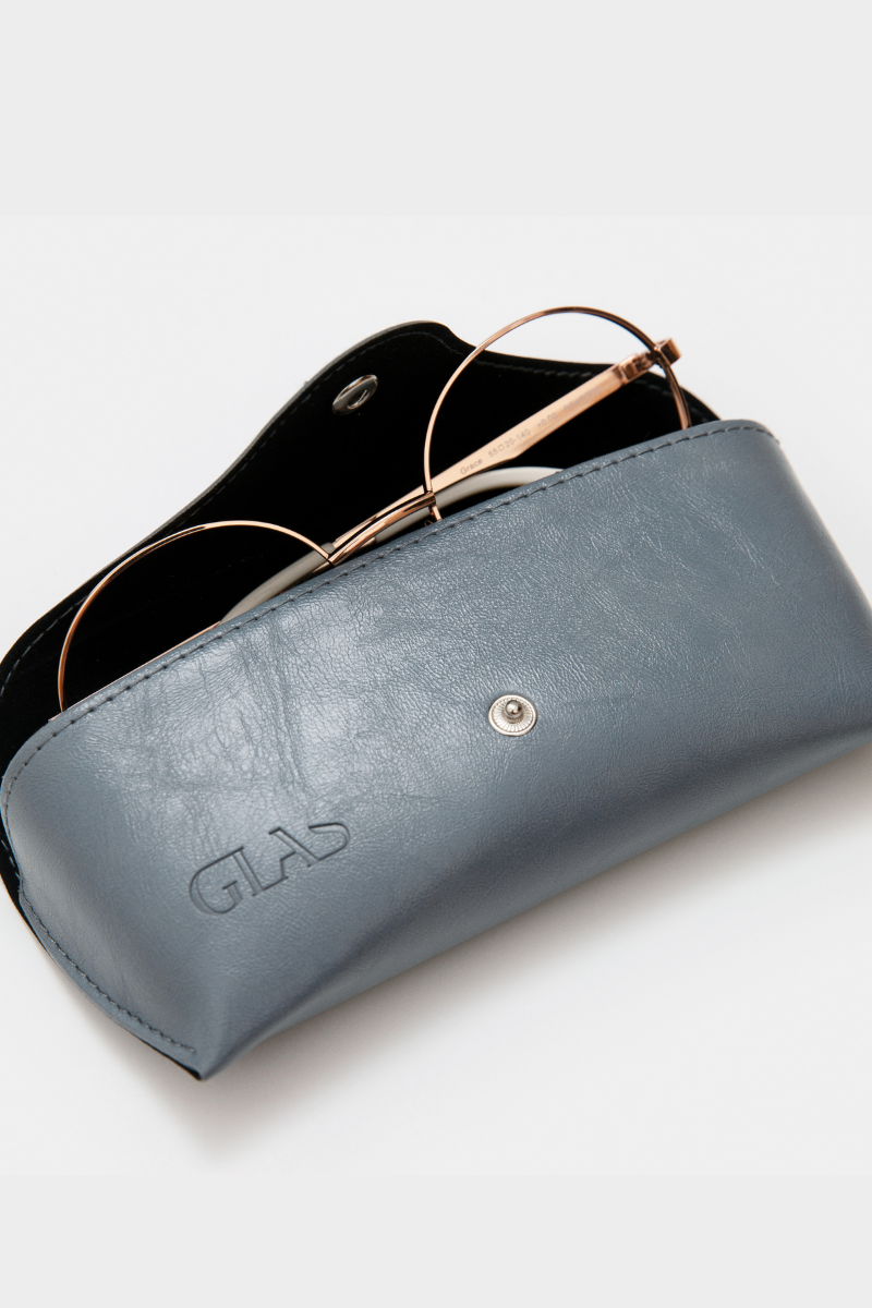 GLAS Vegan Leather Case. A vegan leather glasses case with button closure in the shade dusty blue.