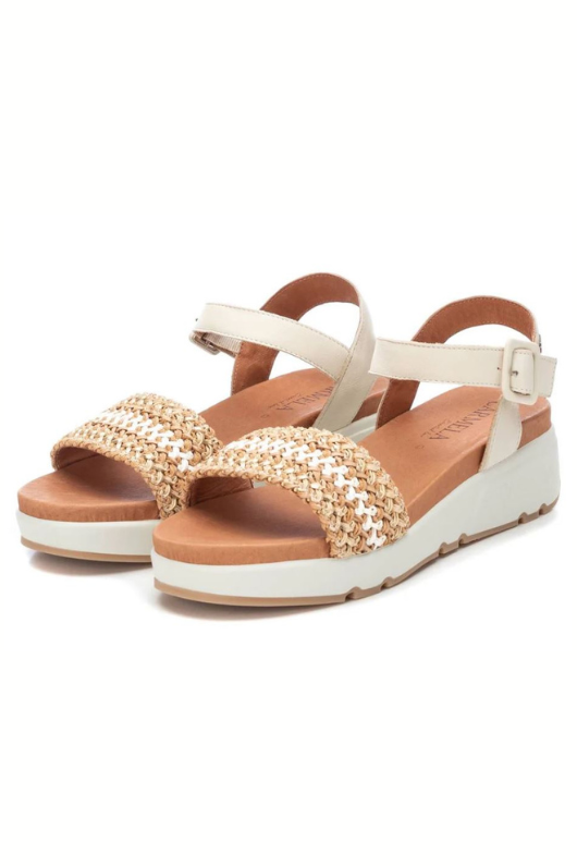 Carmela Low Wedge Sandal. A pair of beige and white leather sandals with braided design and sports style non-slip sole.